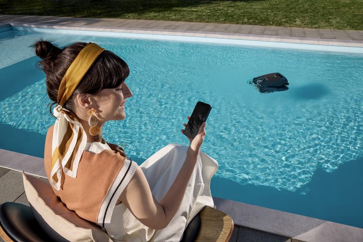 woman using app to control her robot pool cleaner