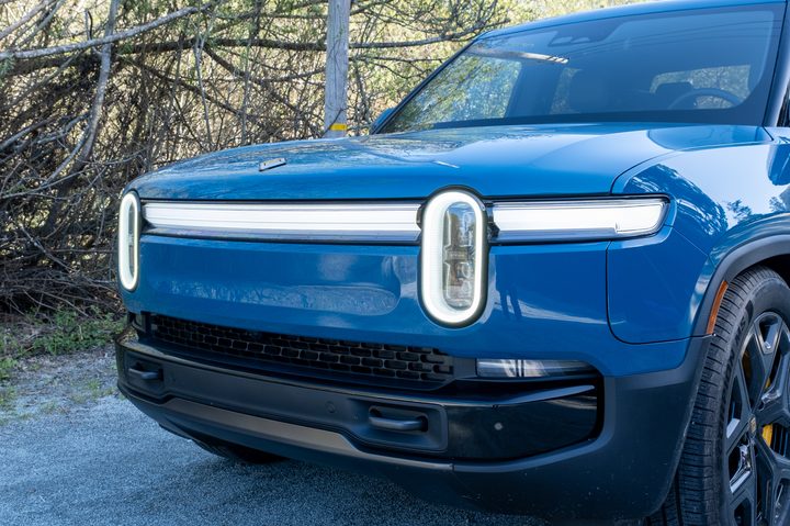 The headlights of a blue 2025 Rivian R1T truck
