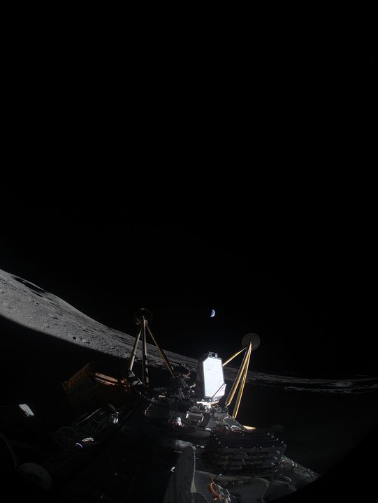 The Intuitive Machines Athena lander is seen on its side on the lunar surface.