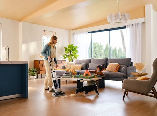 woman cleaning living room while child plays