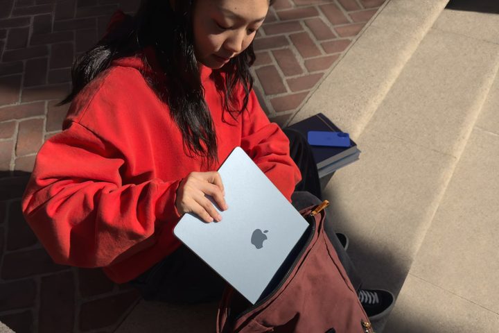 A person putting the Apple MacBook Air with M4 chip in a bag.
