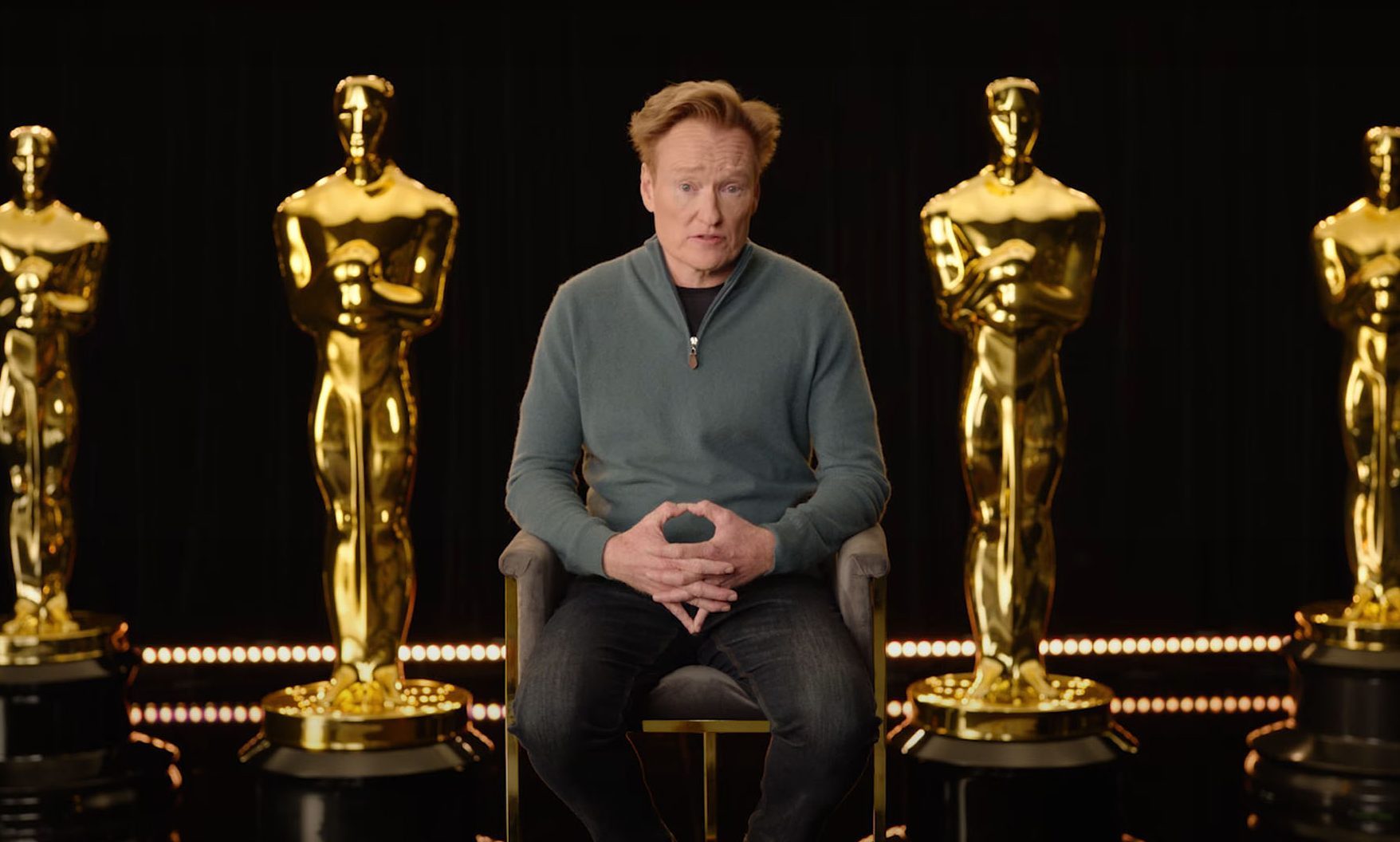 Conan O'Brien sits among giant Oscars.
