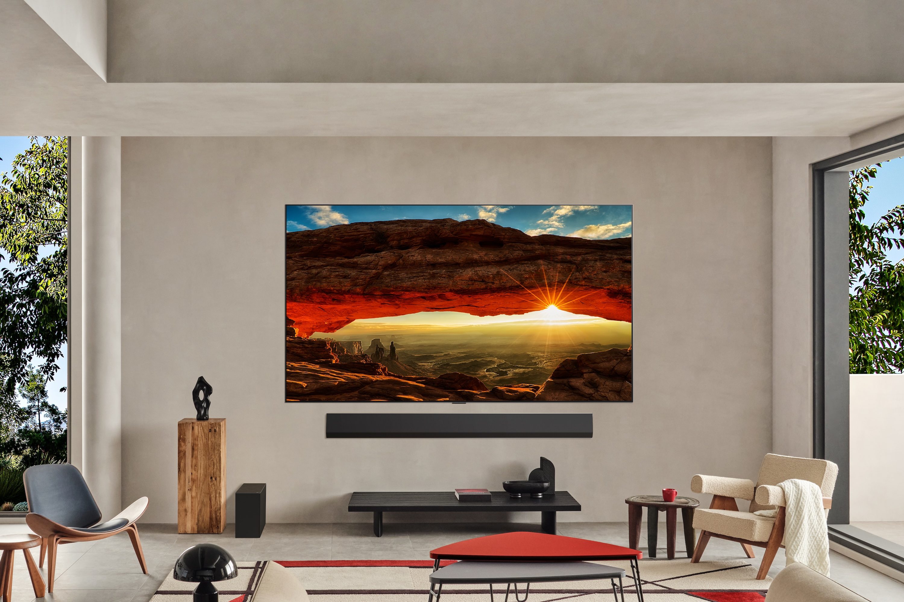 An LG G5 OLED TV hanging on a wall in a bright living room.