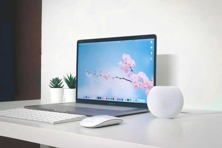 A MacBook Pro, a Magic Mouse, a Magic Keyboard, and a HomePod mini on a desk.