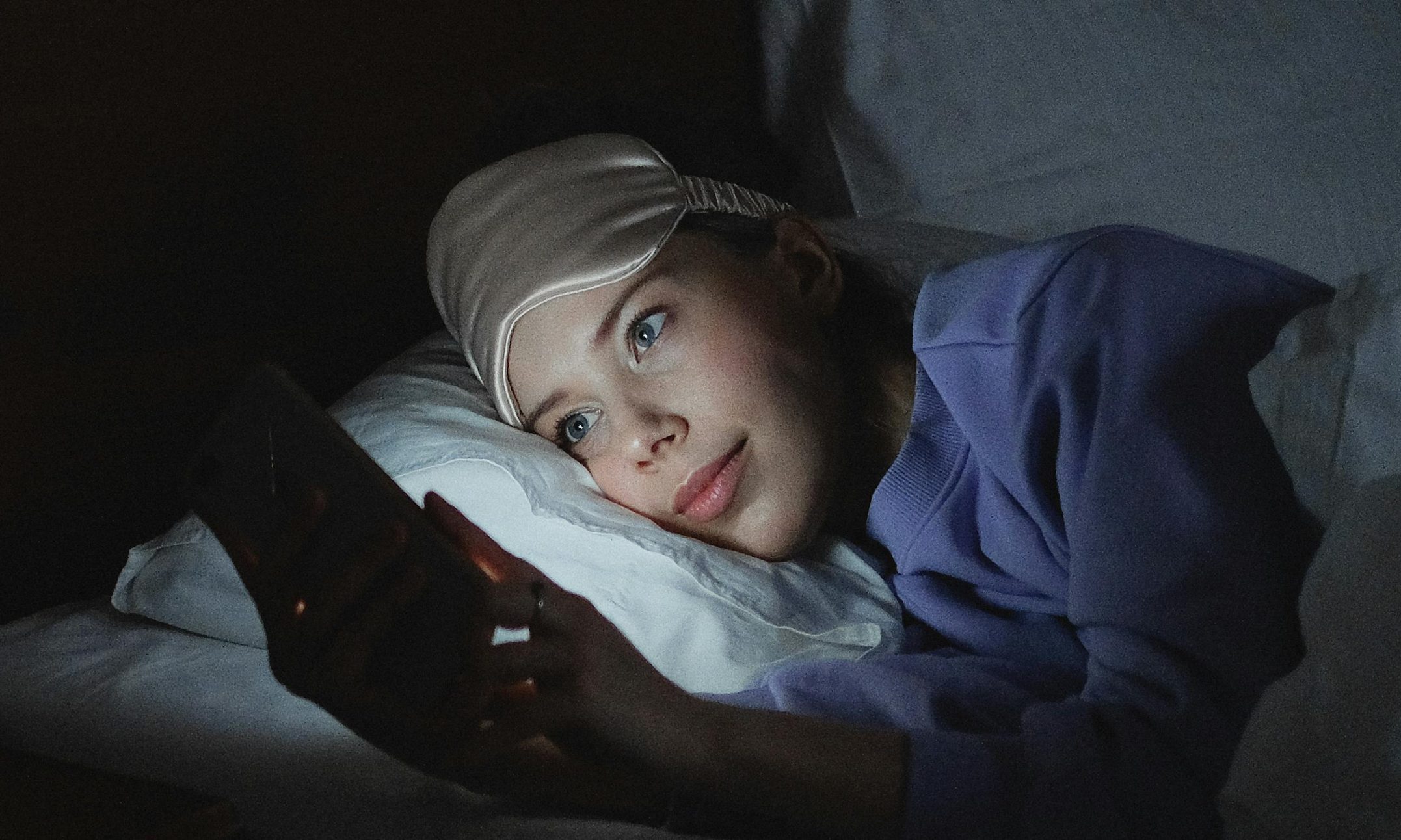 Person using a phone on bed.
