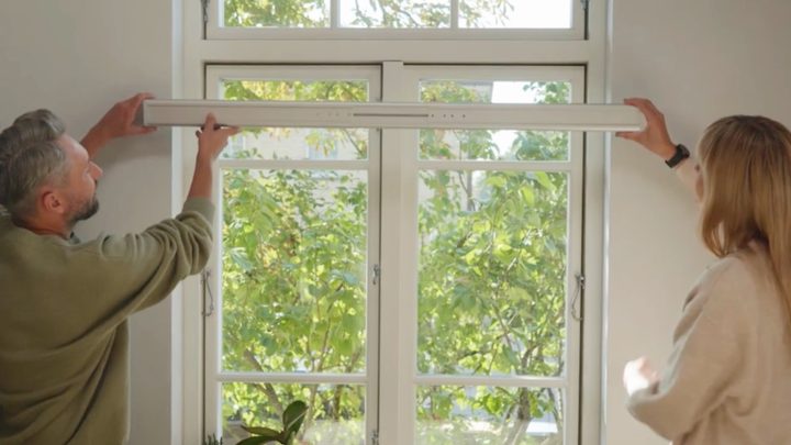 Two people putting up the Roller Shade