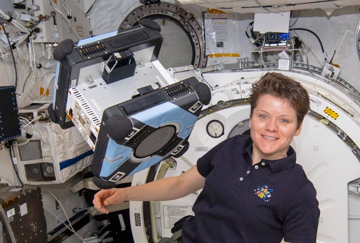 Anne McClain with an Astrobee robot.