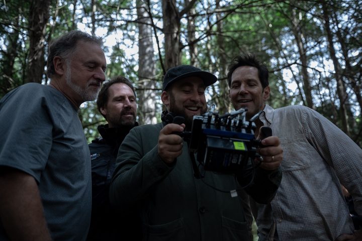 A director holds up a monitor as people look.