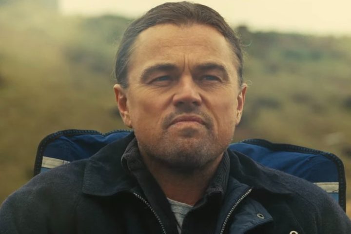 Leonardo DiCaprio sits and stares.