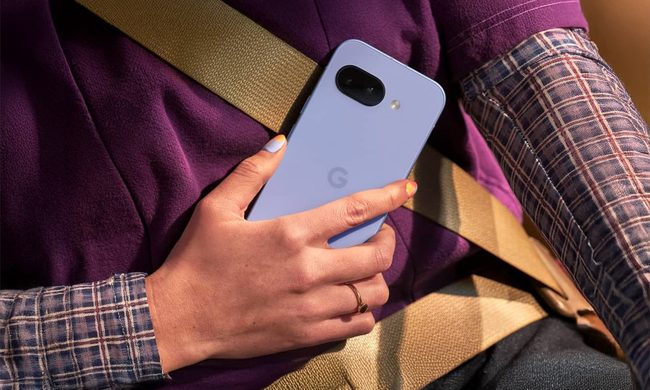 Person holds Pixel 9a in hand while sitting in a car.