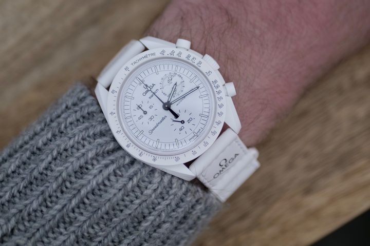 A person wearing a Swatch Moonswatch.