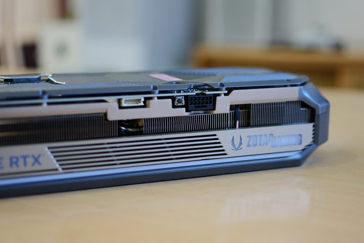 The 16-pin power connector on the Zotac RTx 5070 Ti Amp Extreme Infinity along with a BIOS button and custom RGB lighting control header