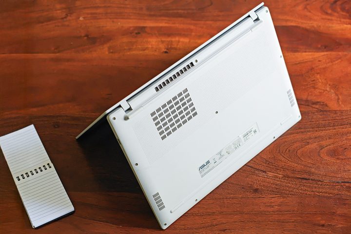 Bottom of the silver Asus Vivobook 16 X1607QA Copilot+ PC laptop with Qualcomm Snapdragon X ARM 64 chip on a wooden surface.