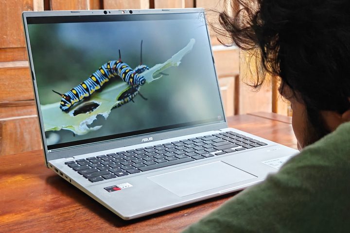 16-inch display of the Asus Vivobook 16 X1607QA Copilot+ PC laptop with Qualcomm Snapdragon X ARM 64 chip on a wooden surface.