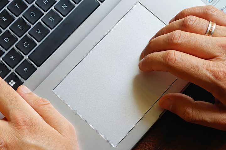 Touchpad on the Asus Vivobook 16 X1607QA Copilot+ PC laptop with Qualcomm Snapdragon X ARM 64 chip on a wooden surface.