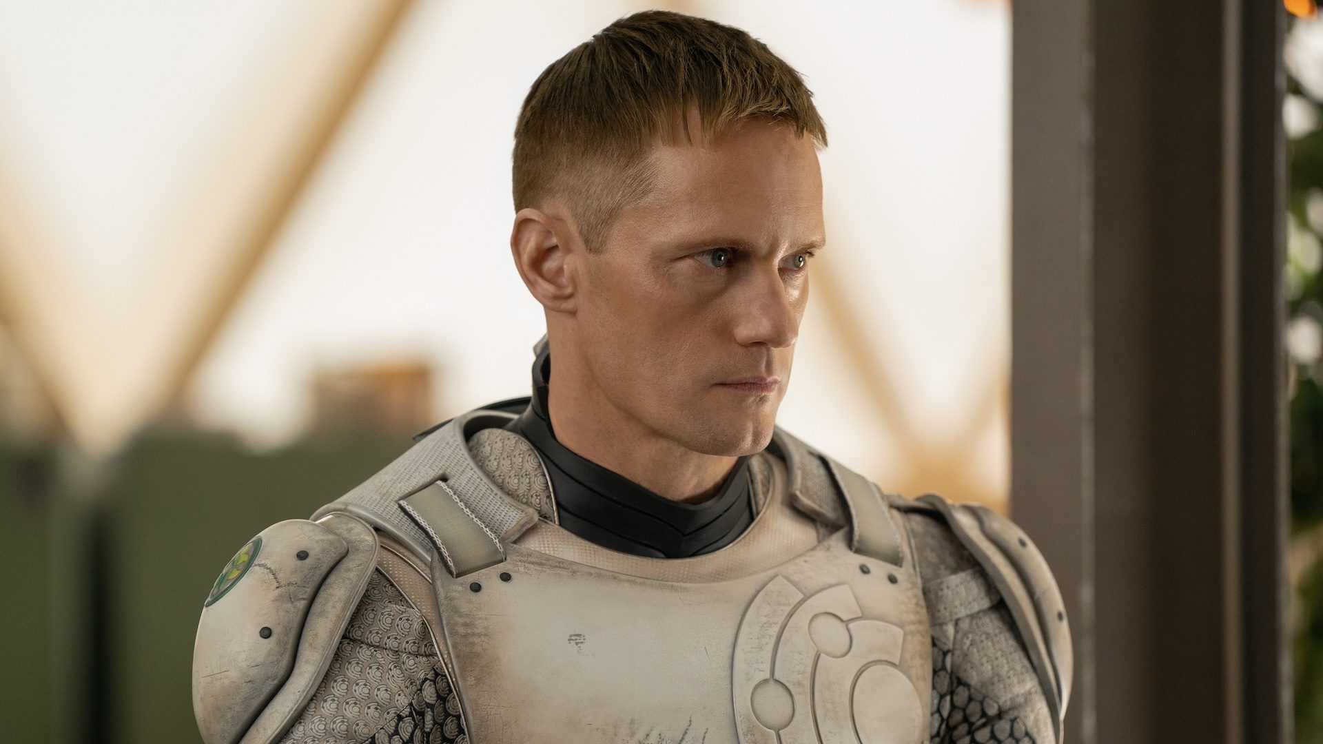Alexander Skarsgard looks to hs left and stares.