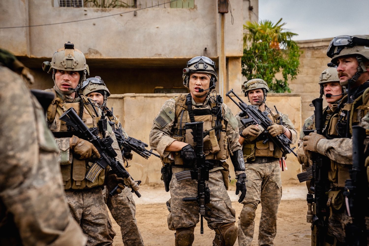 A group of soldiers stand in the road.