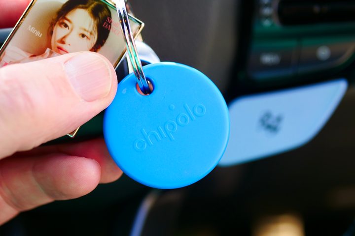 A person holding a blue Chipolo Pop.