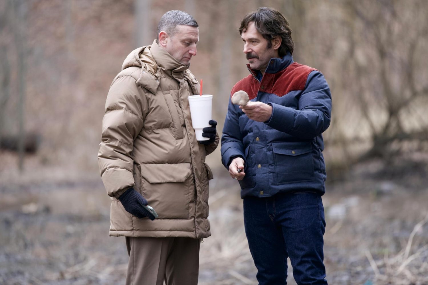 A man hands another man an item.