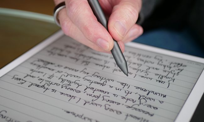 A person using the Amazon Kindle Scribe and its stylus.