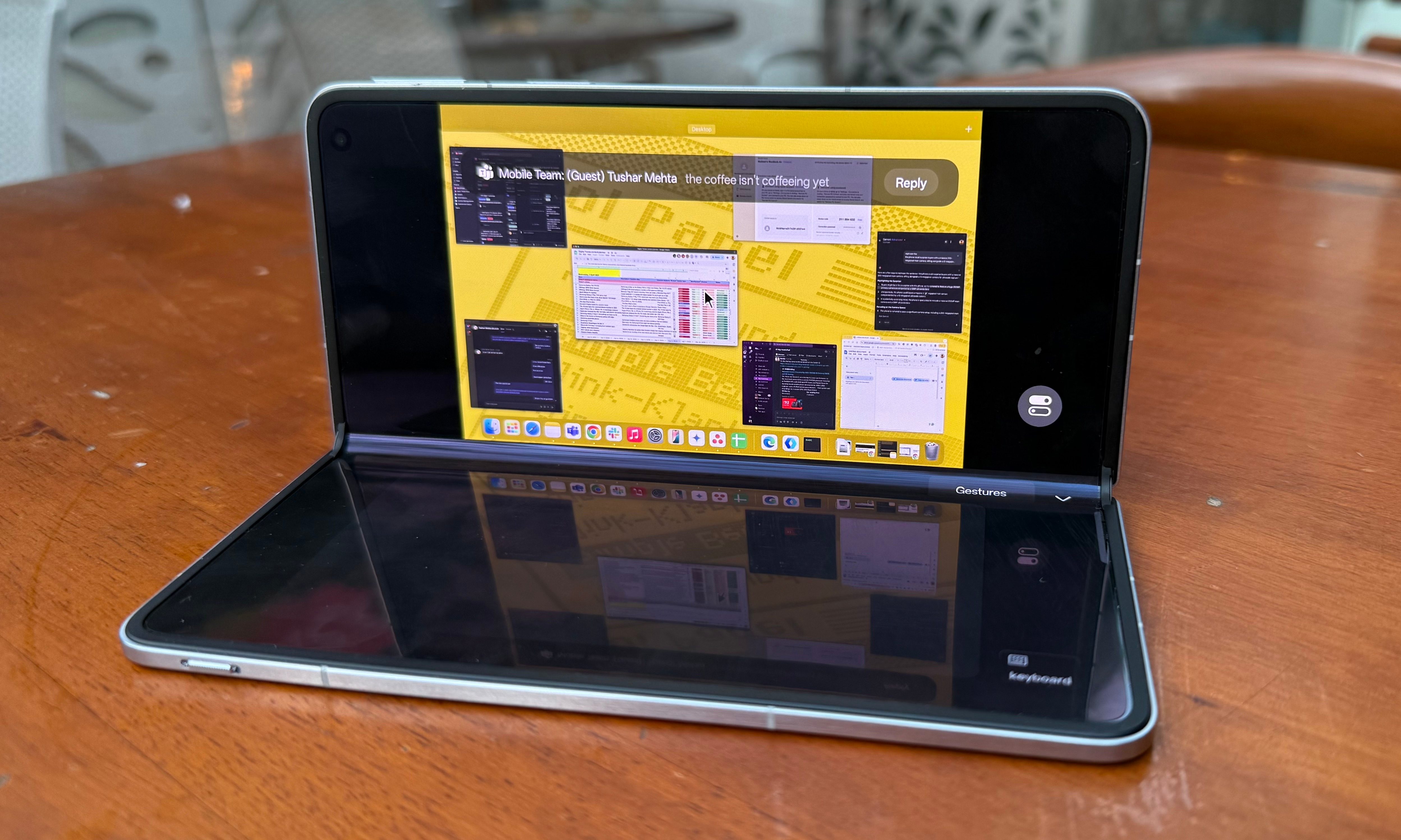 An individual is remotely operating a Mac from an Oppo Find N5.