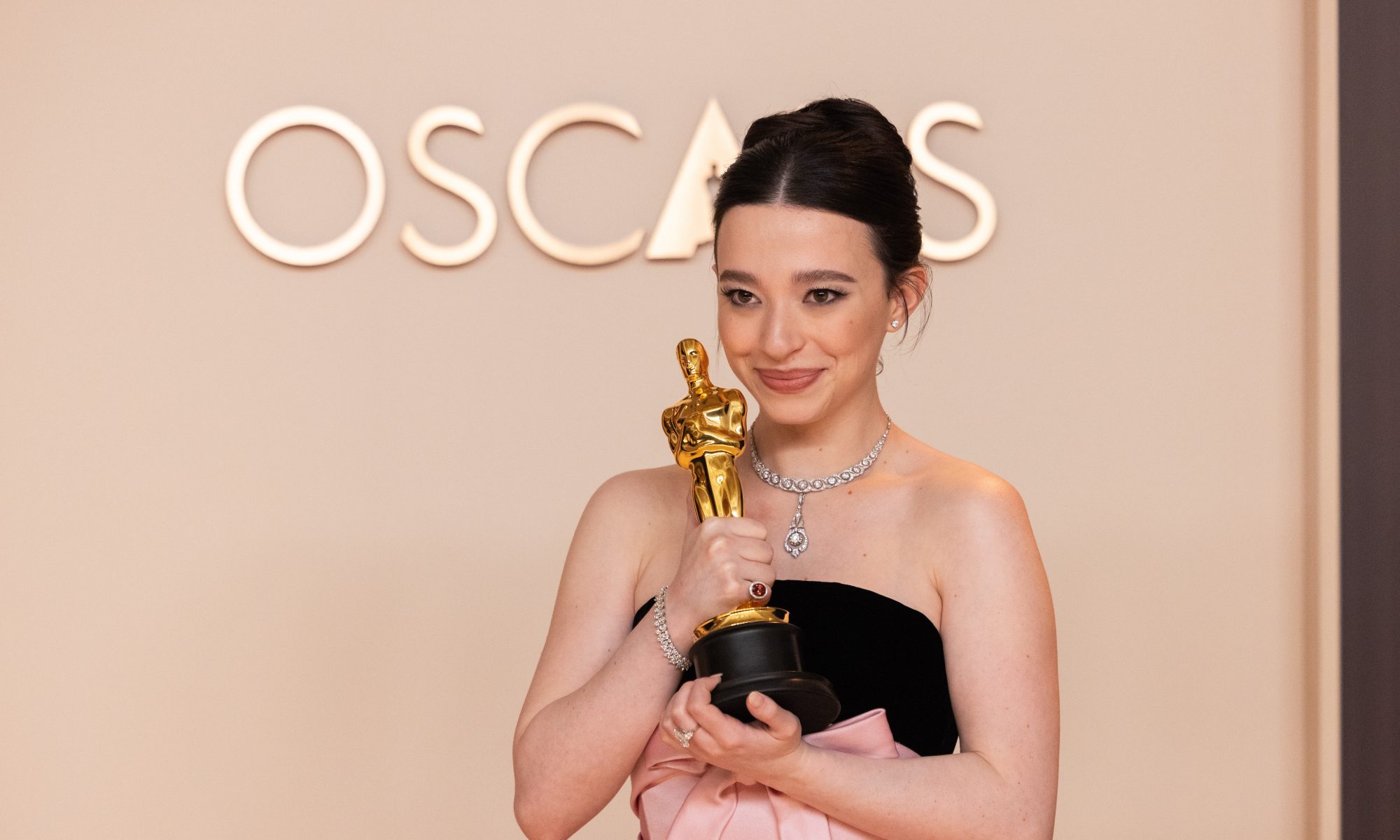 Mikey Madison poses backstage with the Oscar award,