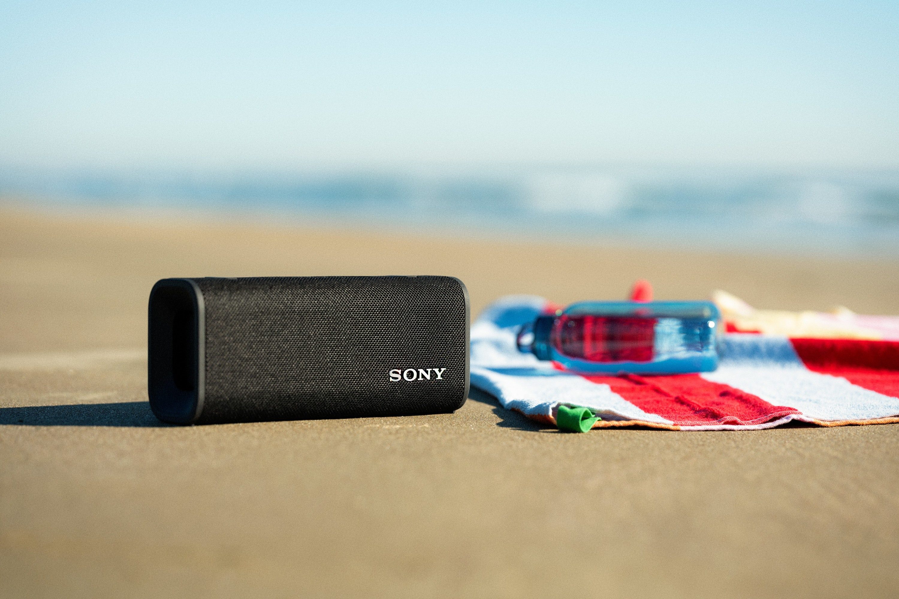 The Sony ULT Field 3 Bluetooth speaker on a beach.