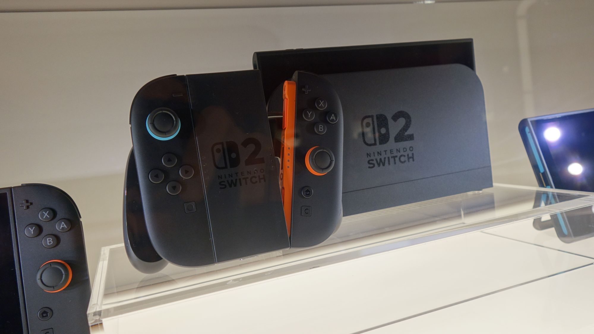 A Switch 2 sits on a display next to its controller.