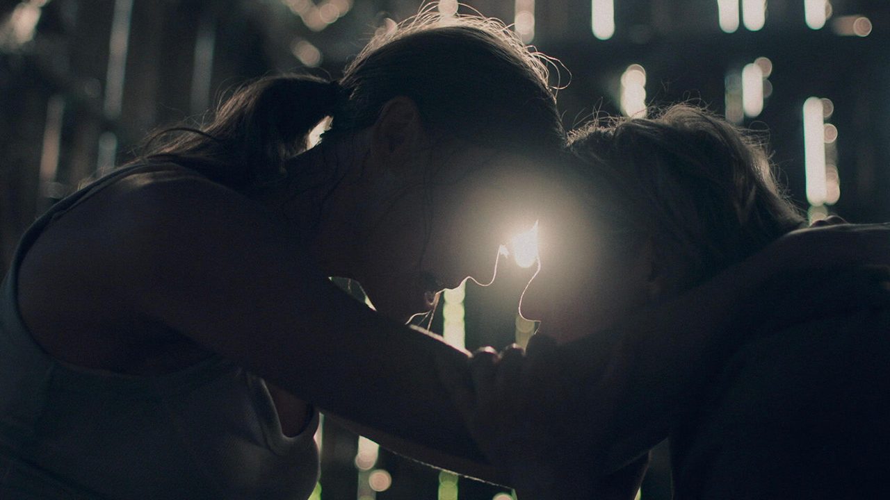 Serena and June with their foreheads together embracing as Serena goes into labor in The Handmaid's Tale.
