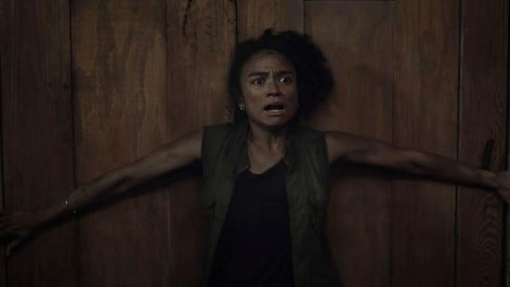 Connie standing by a door, arms outstretched looking terrified in The Walking Dead.
