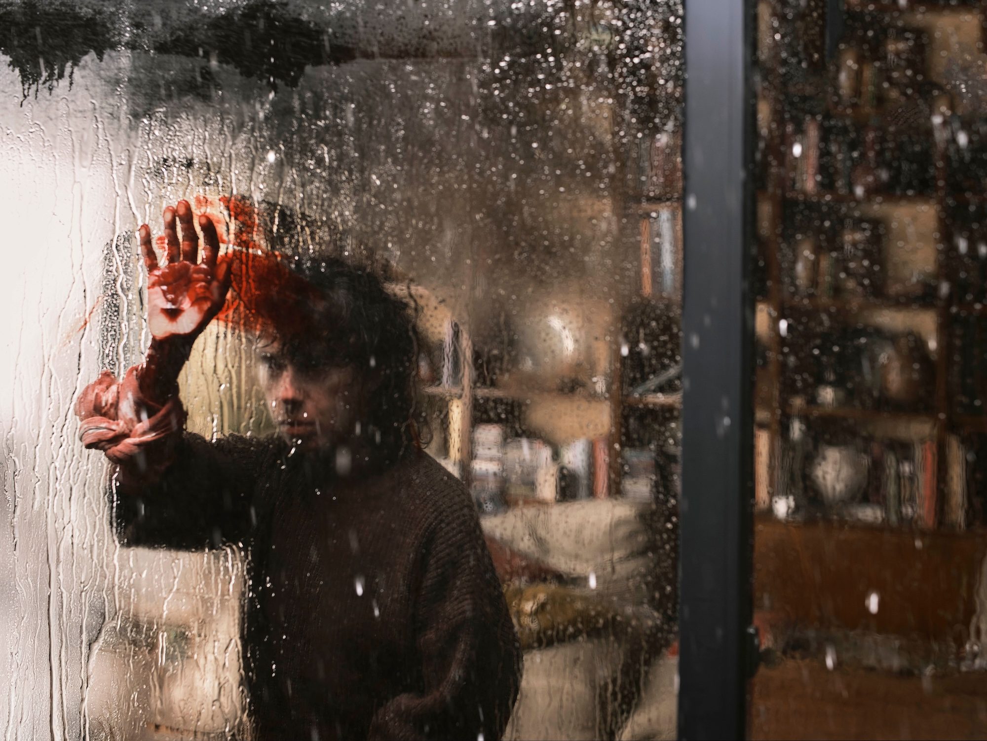 A woman puts her hand on the window.