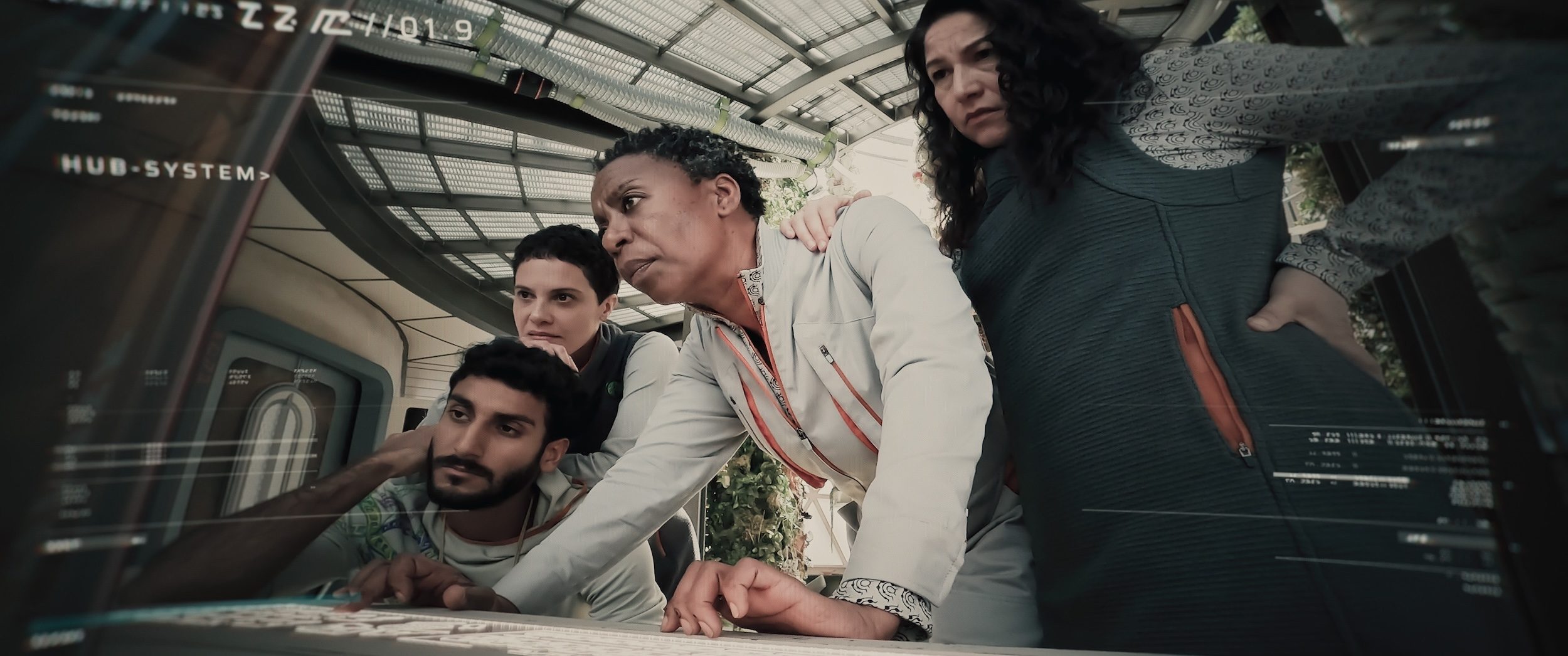 A group of people crowded around a computer.