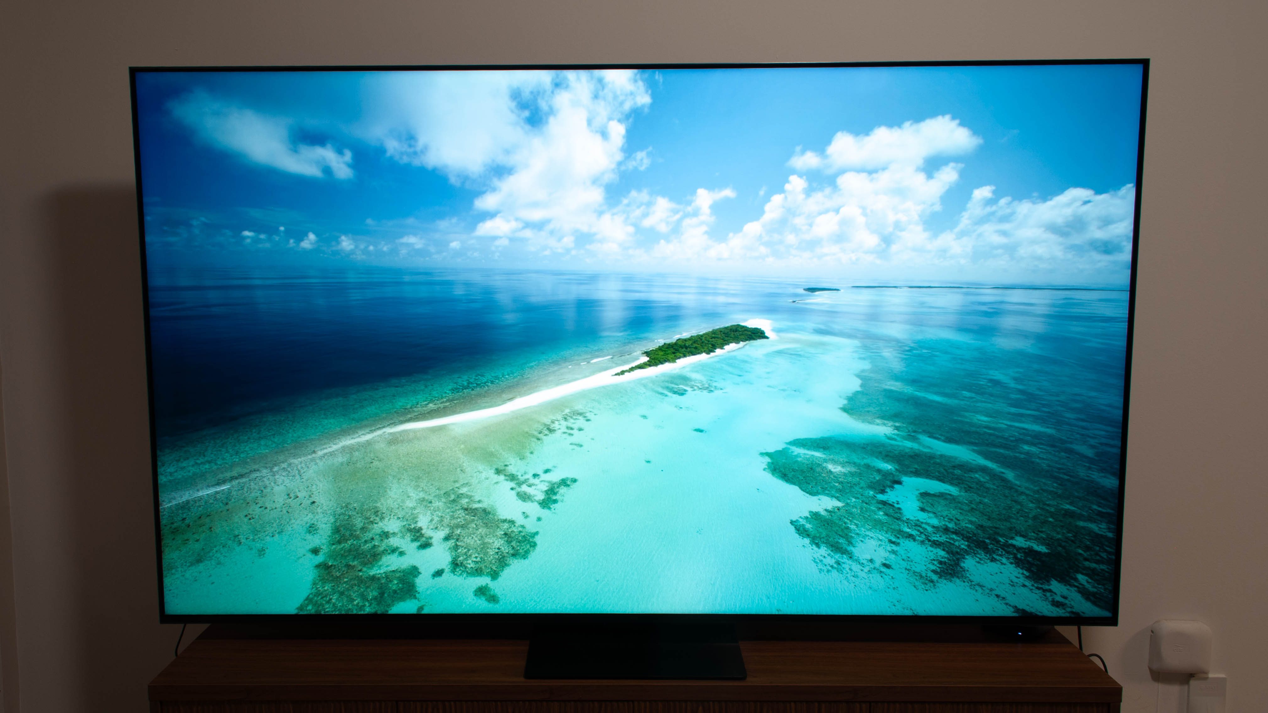 The TCL QM7K QD-Mini LED 4K TV with a beach scene on the screen.
