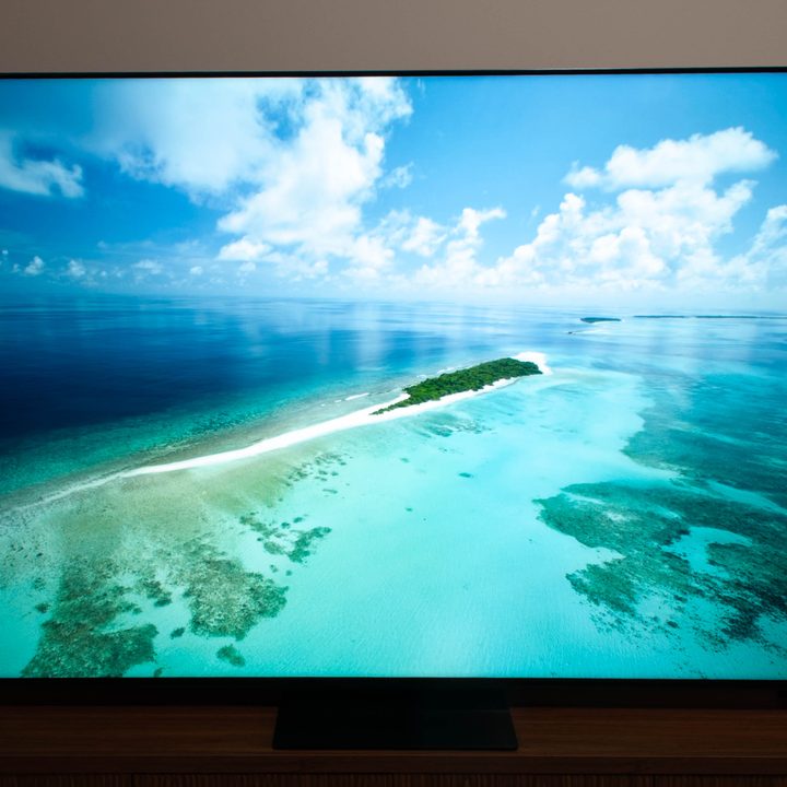 The TCL QM7K QD-Mini LED 4K TV with a beach scene on the screen.