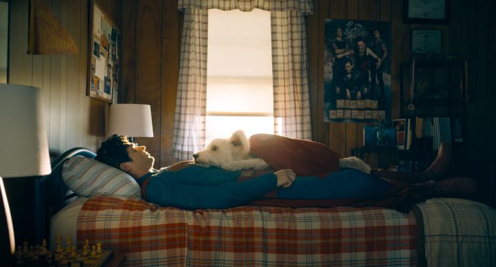Superman lying on a bed with Krypto on his stomach in "Superman."