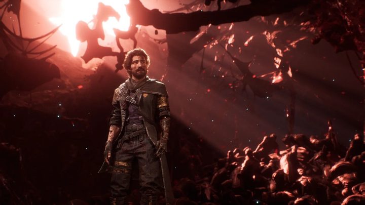 A bearded man stands inside a red cavern littered with bodies