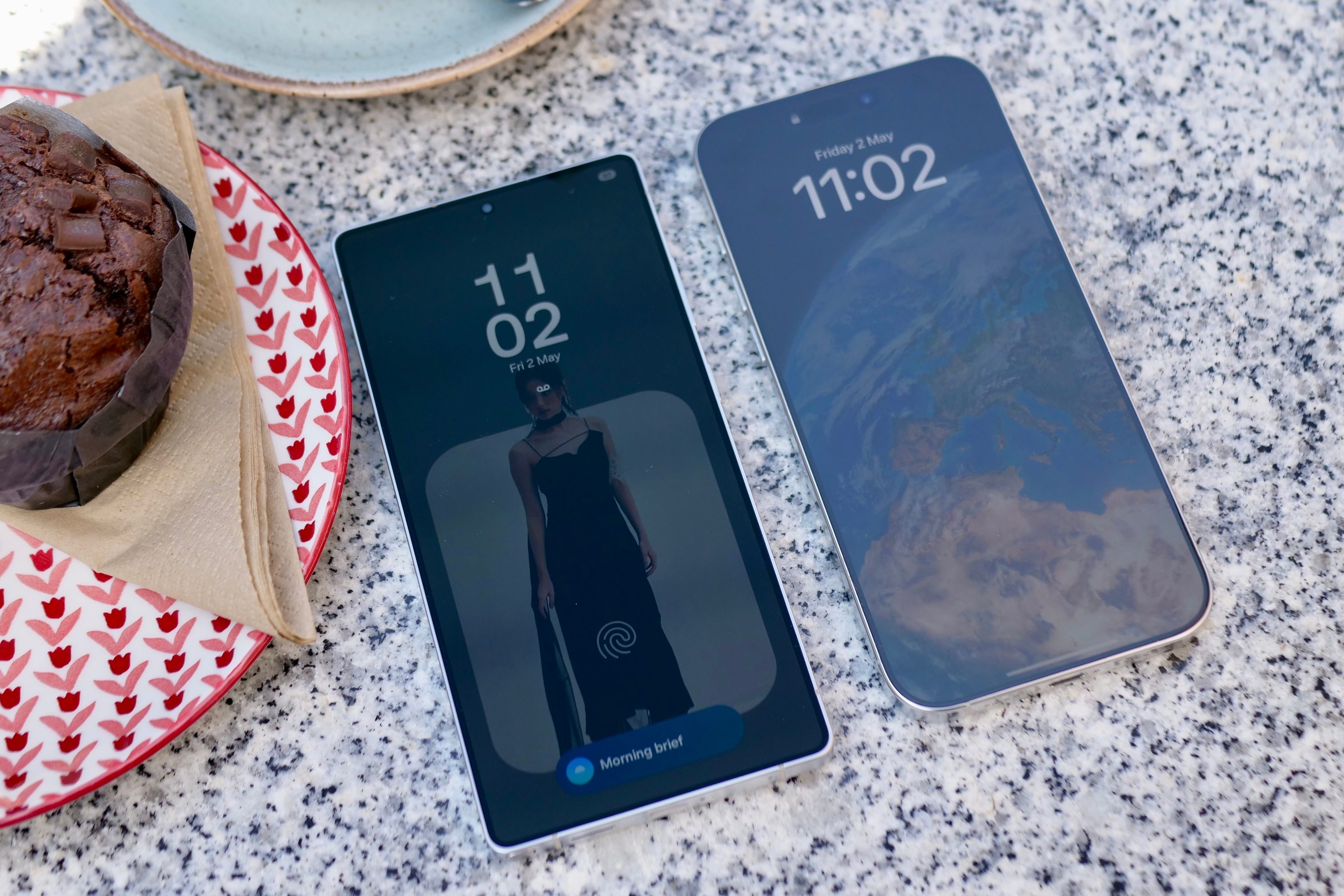 The Samsung Galaxy S25 Ultra with the Apple iPhone 16 Pro Max, showing the screen reflection.