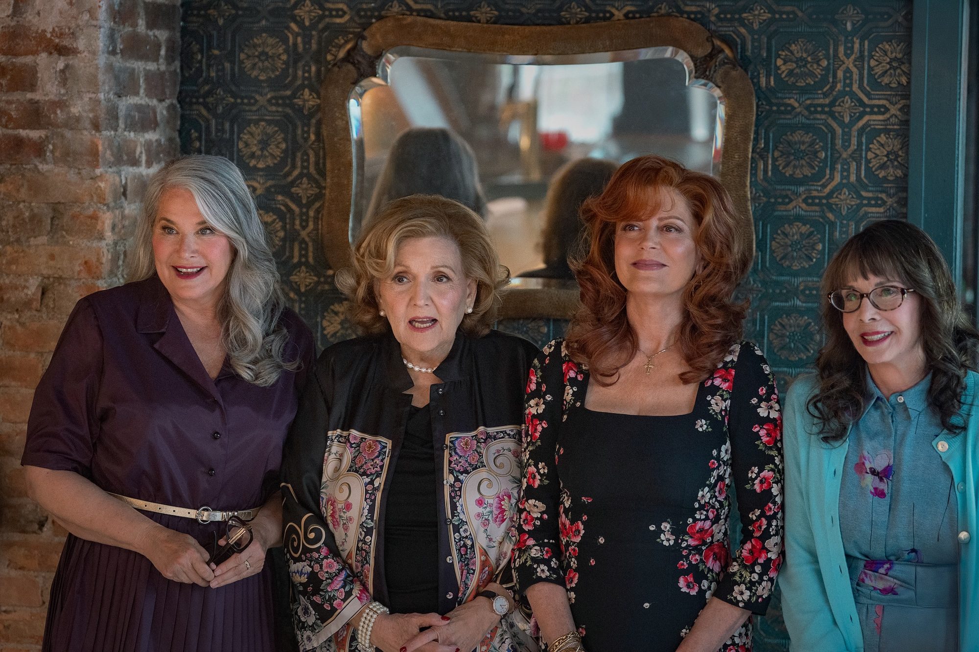 Four women look amused and stand in a line in Nonnas.