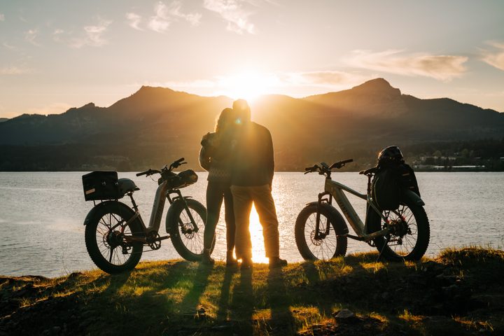 couple taking in a sunset after riding their e-bikes