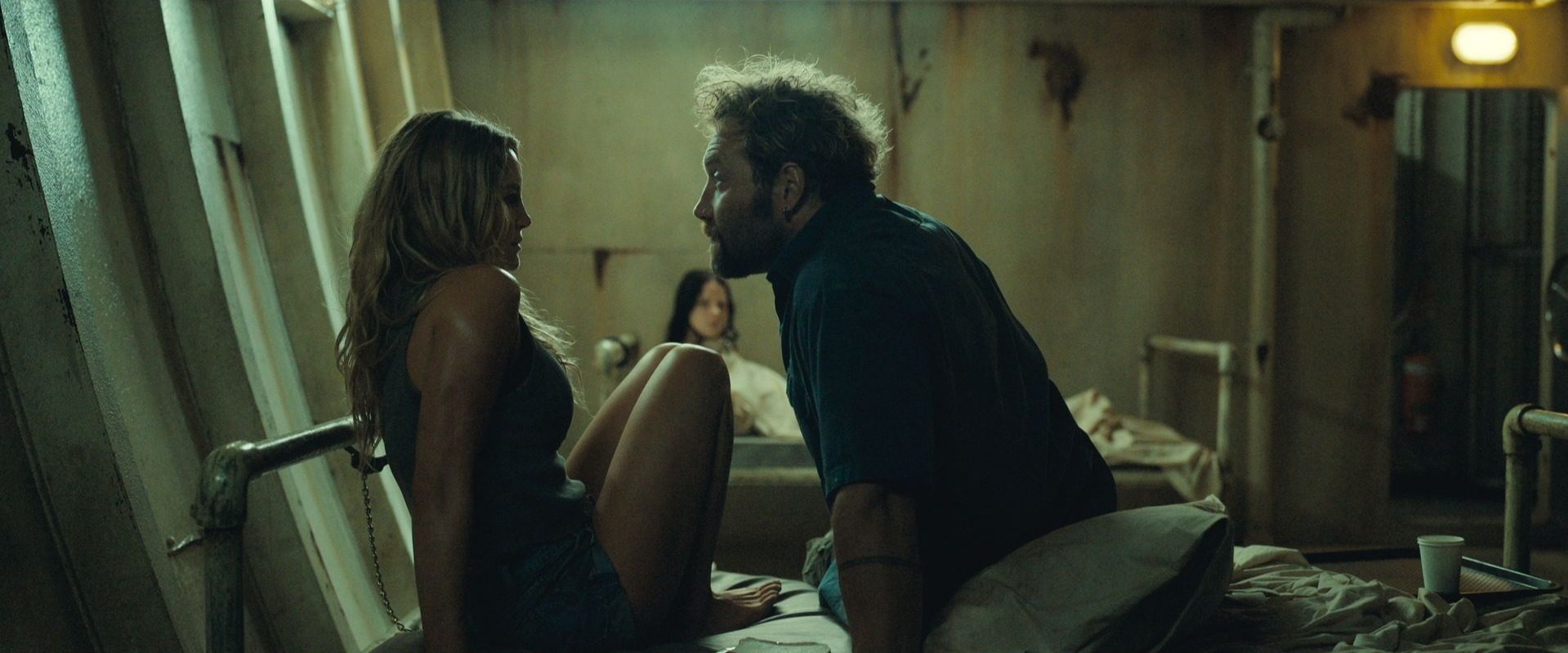 A man corners a woman on a bed in Dangerous Animals.