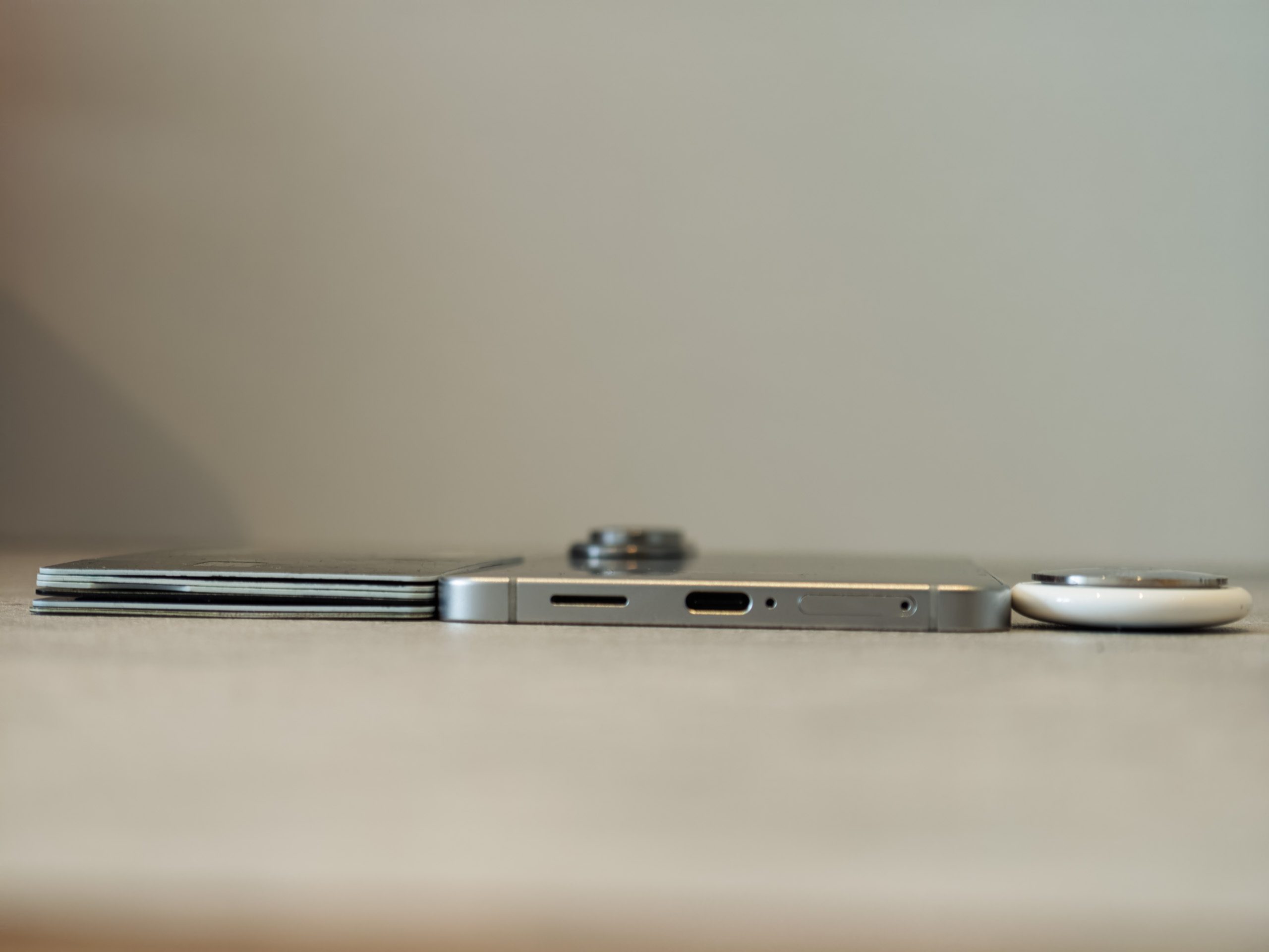 Galaxy S25 Edge next to six credit cards and an airtag