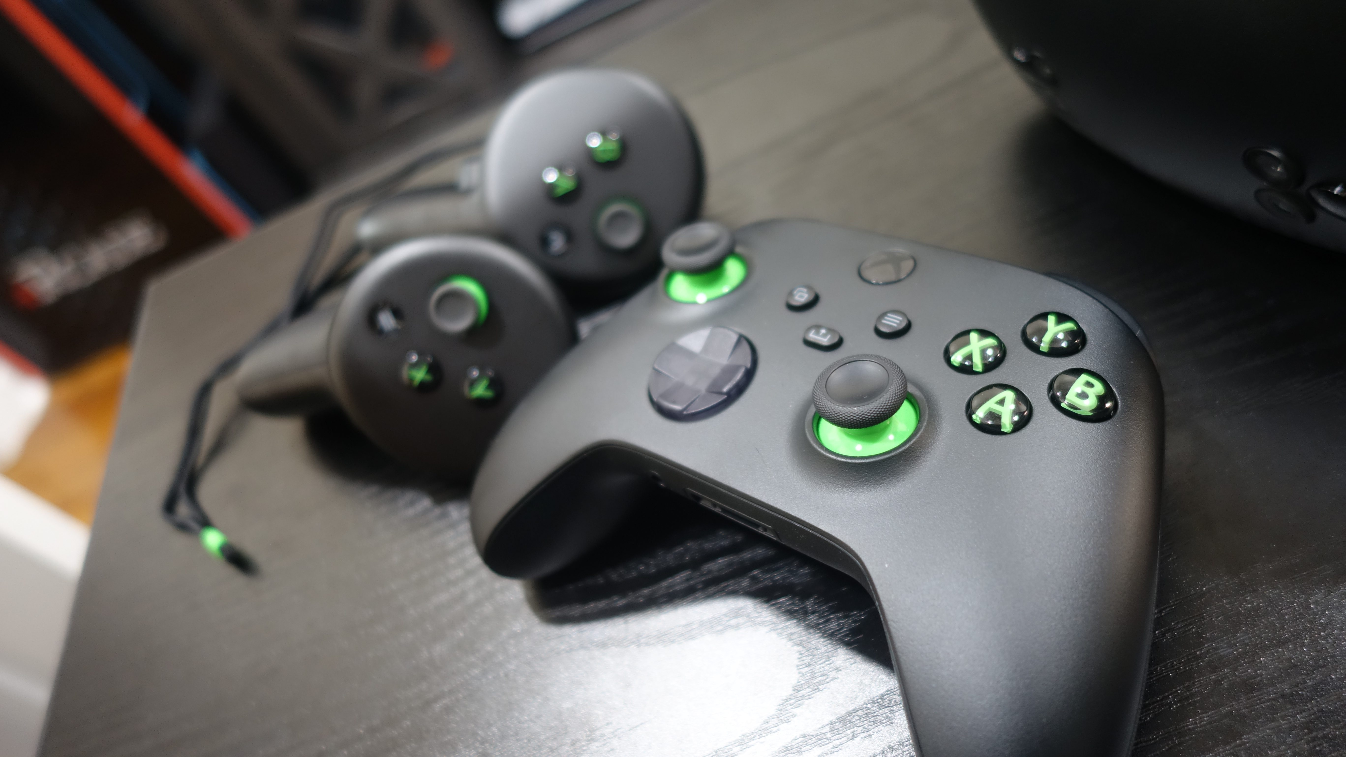 An Xbox controller and themed Meta Touch controllers sit on a table.