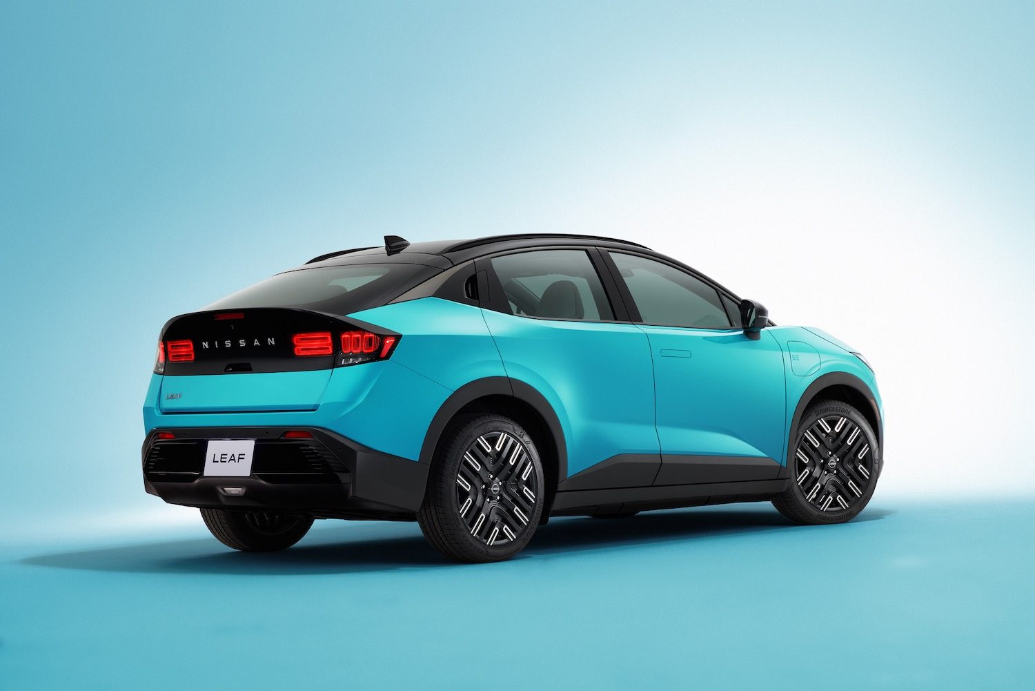 2026 Nissan Leaf rear quarter view, studio background.