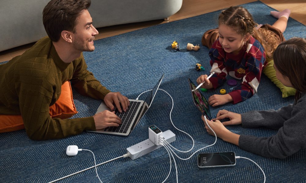 A family surrounds their 4-port 140W Anker Charger.