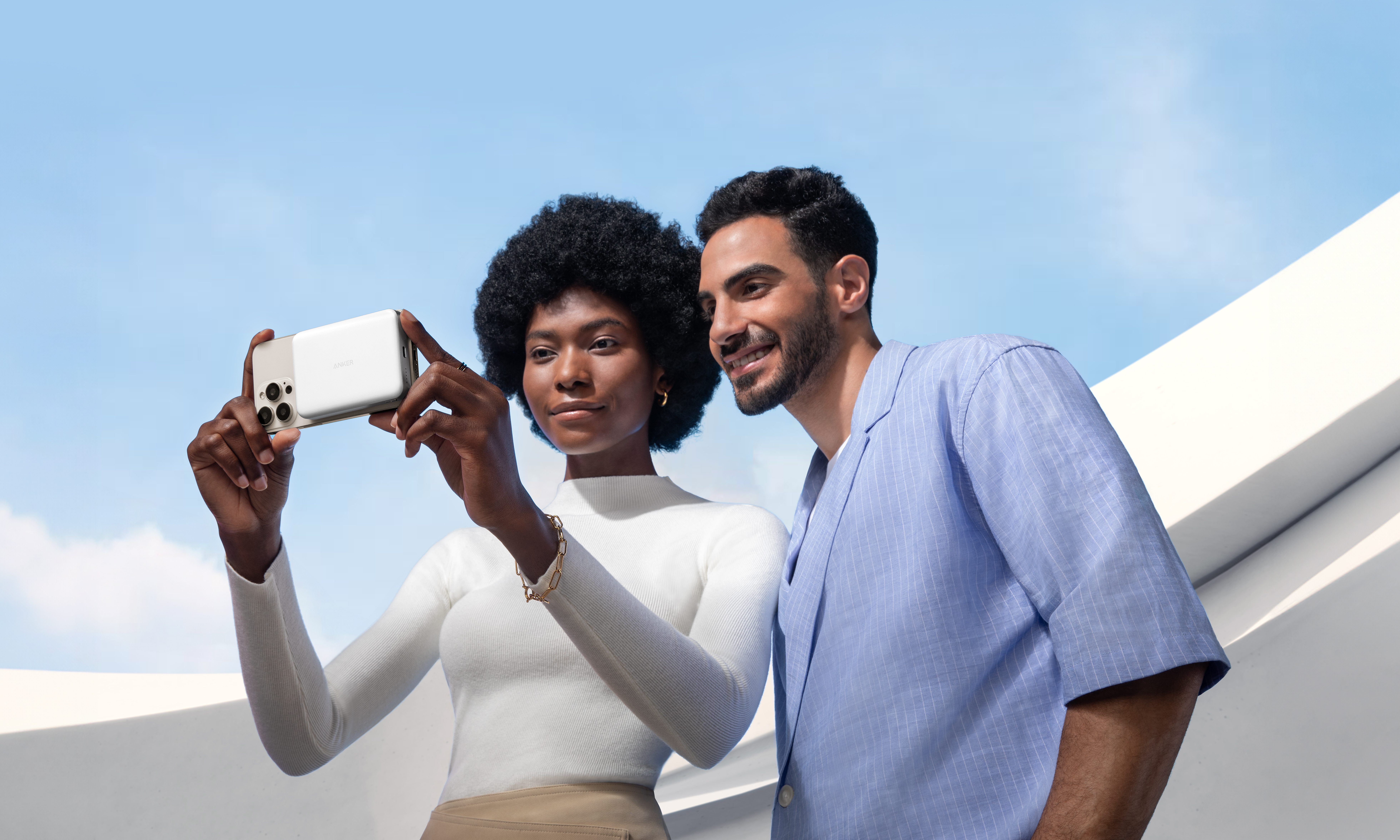 A couple pose for a selfie with a phone charged by an Anker MagGo Power Bank.