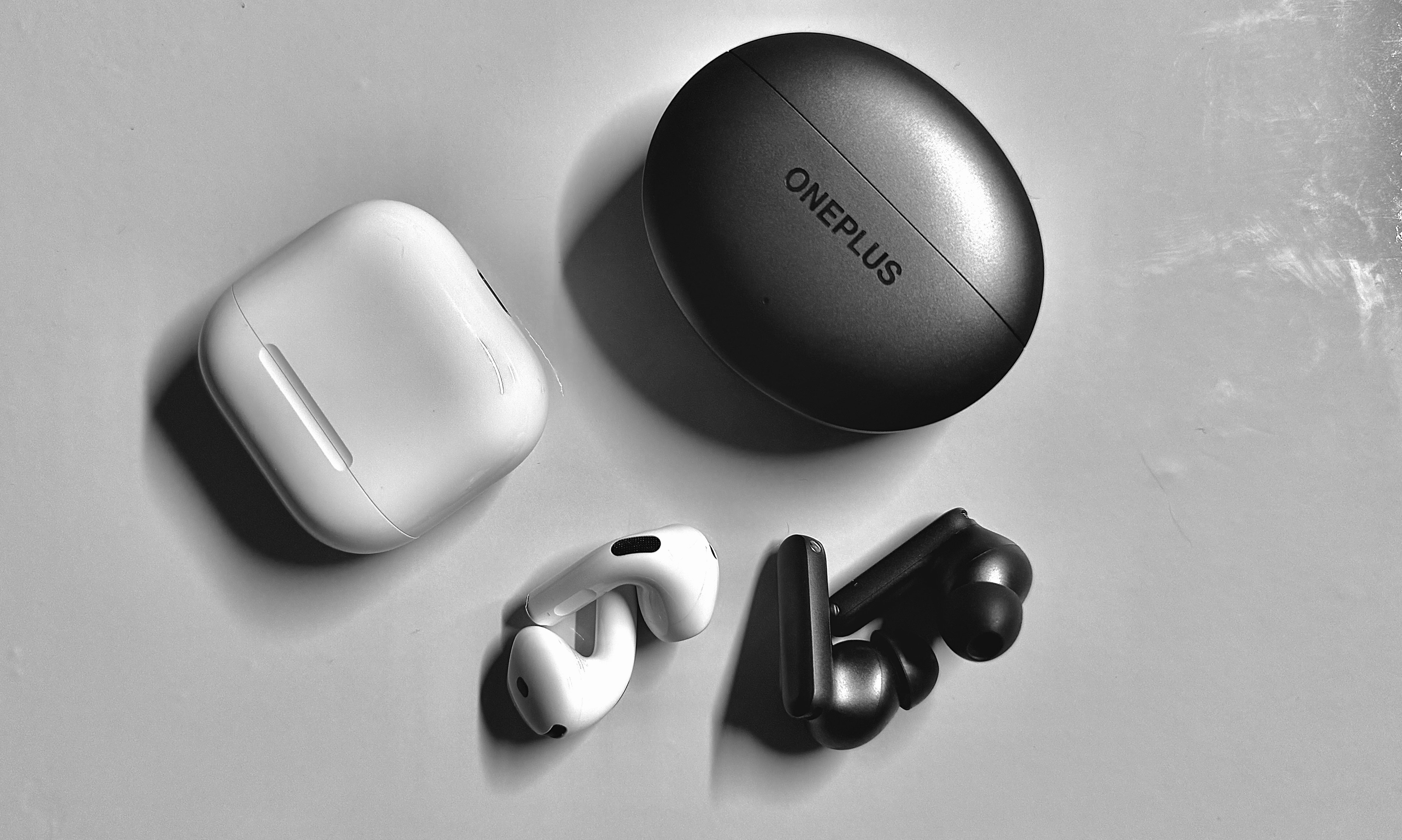 AirPods 4 and OnePlus Buds outside their case.