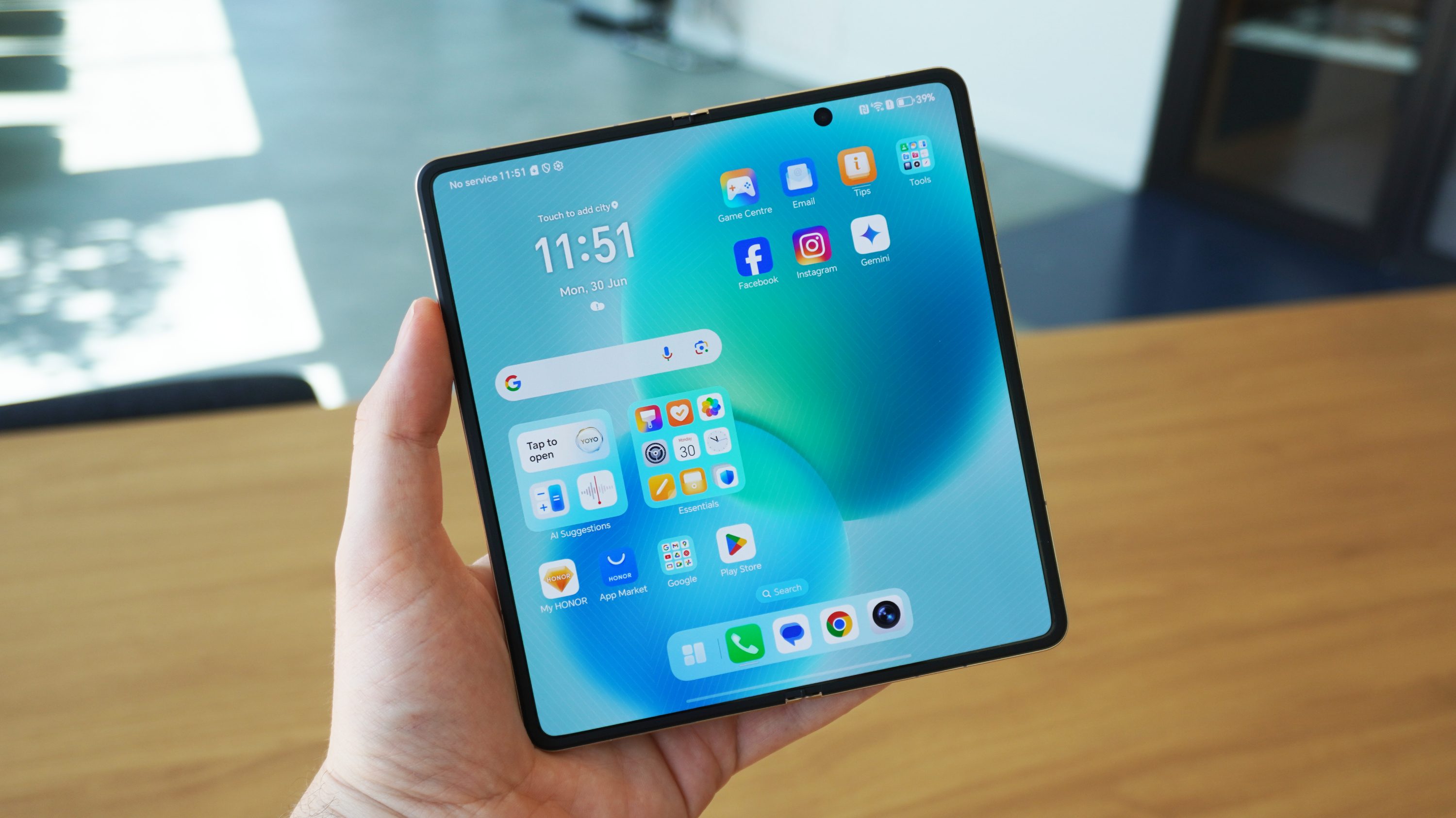 The Magic V5 unfolded with the screen on, held in a hand