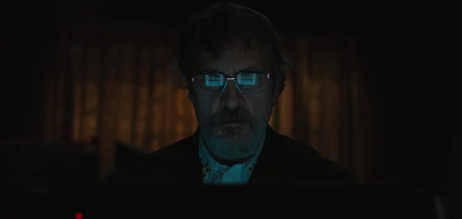 Joaquin Phoenix looking at a computer screen in Eddington.