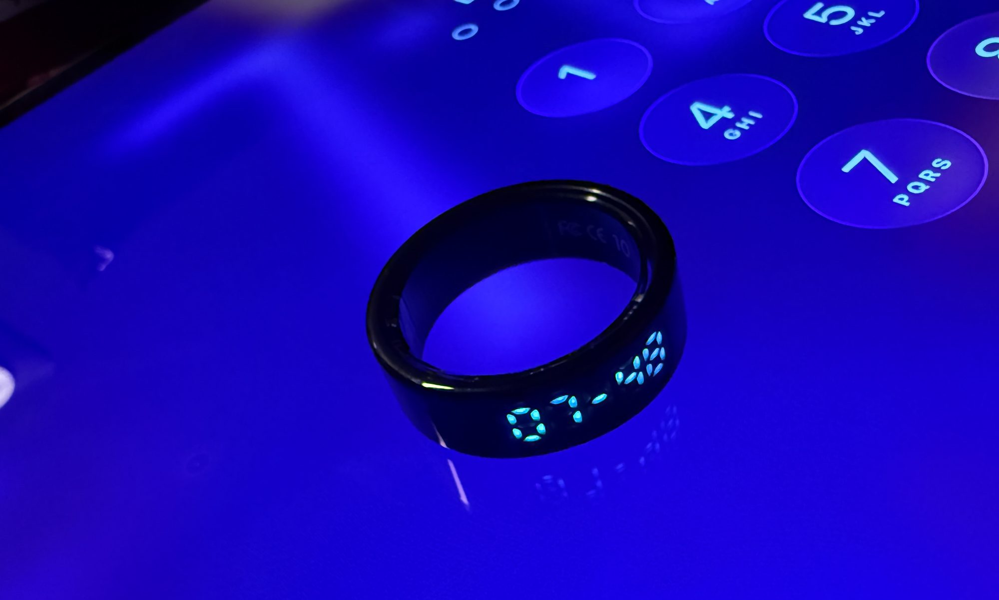 Pebble Halo smart ring lying atop a display.