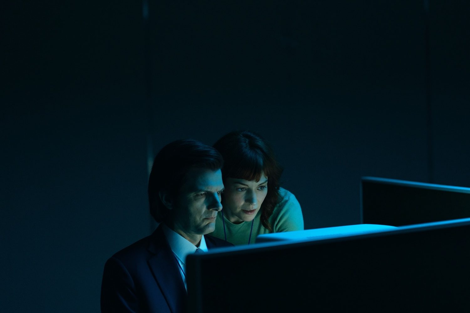 Two people stare at a computer.